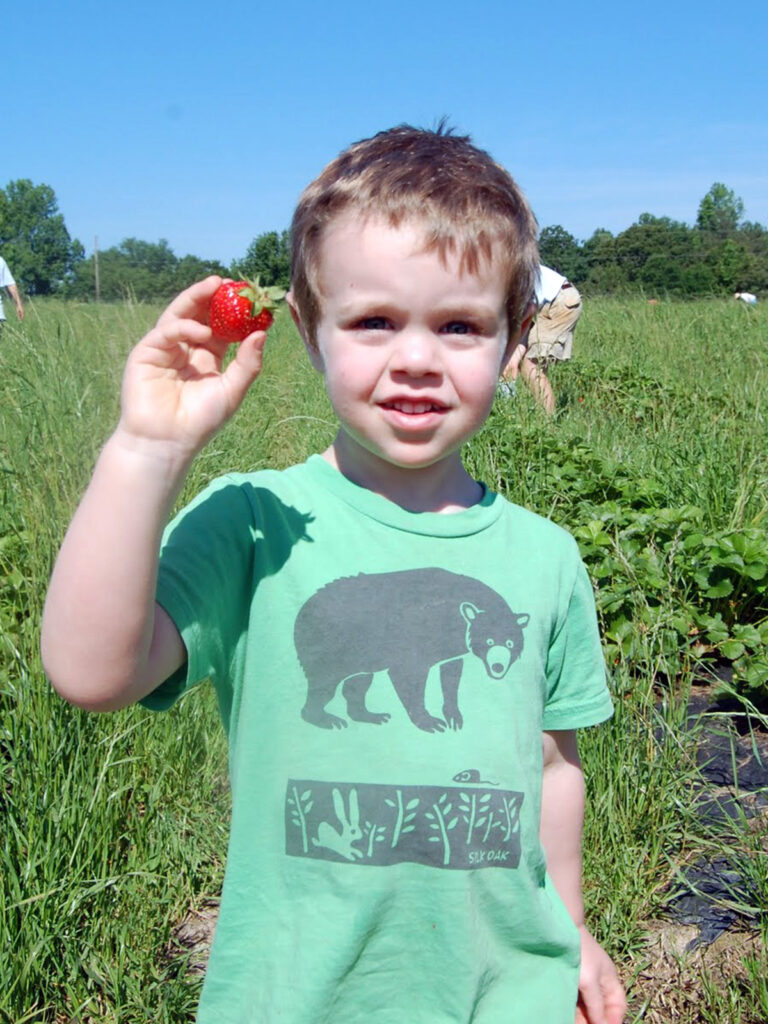 A child with a strawberry